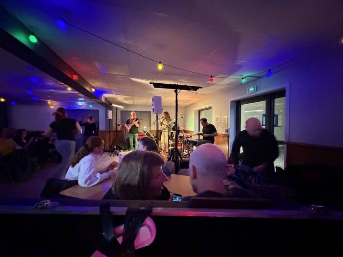 Groupe de musique jouant dans un bar avec guirlandes lumineuses