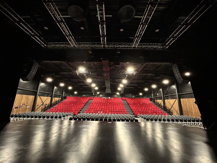 Vue depuis la scène d'une salle de théâtre avec gradins rouges